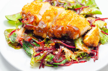 Breaded crispy chicken breast fillet with mixed salad and grated beetroot