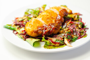 Breaded crispy chicken breast fillet with mixed salad and grated beetroot