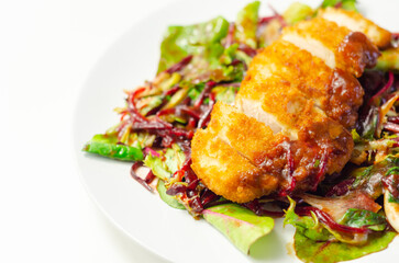 Breaded crispy chicken breast fillet with mixed salad and grated beetroot