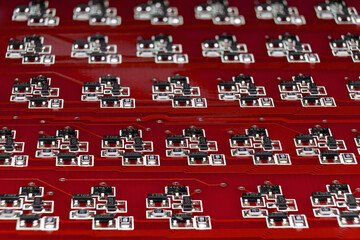 Naklejka premium Close-up of a red electronic circuit board with many SMD components. Complex logical electronic system built on smd components