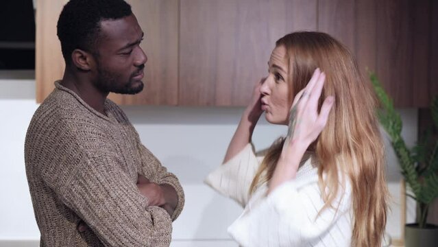 Young couple quarrel. Angry wife screams at her husband and insults him.