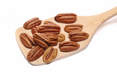 Pecan nuts in wooden spoon isolated on white 
