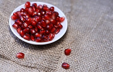 bright red pomegranate seeds on canvas background healthy food
