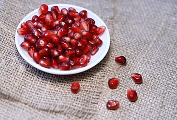 bright red pomegranate seeds on canvas background healthy food