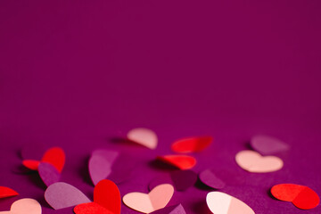 Close up pink purple red paper hearts on purple background. Happy Valentine Day. Greeting card. DIY...