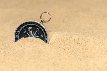 Compass on the sand at the beach. Concept of travel
