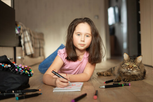 child girl draws sketch with markers. drawing of hearts.