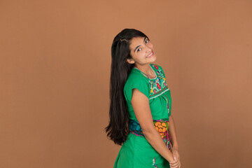 young mexican woman of latin ethnicity in maya dress smiling looking at the camera