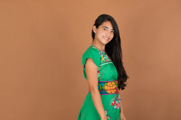 young mexican woman of latin ethnicity in maya dress smiling looking at the camera