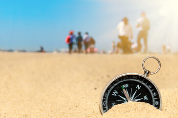 Compass on the sand at the beach. Concept of travel