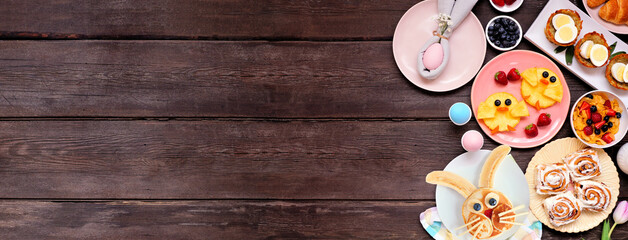 Fun Easter breakfast or brunch side border. Top down view on a dark wood banner background. Bunny...