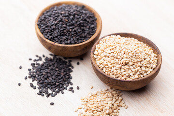 White sesame and black sesame seed on wooden bowl.
