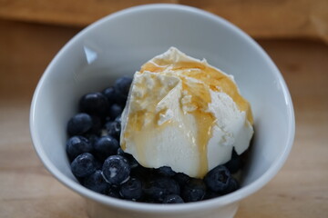 Breakfast honey with cottage cheese and blueberries in a wise bowl