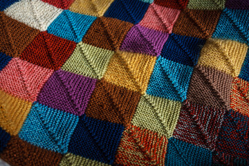 Close-up photo of hand-knitted multicolored woolen plaid