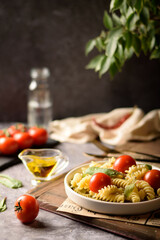 Italian pasta with tomatoes on a dark background. Fusilli pasta