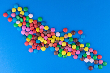 Multicolored candies on a bright blue background.Top view