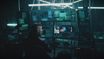 A male hacker in a casual jacket on a chair, hacking a nuclear weapon launch on a computer with a...
