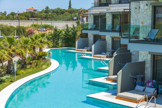 Beautiful view of exterior of hotel building with access from room to patio and private part of pool. Greece. 