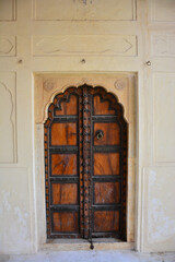 Traditional ornamental wooden door in Amber Fort, Mughal palace in Jaipur, India