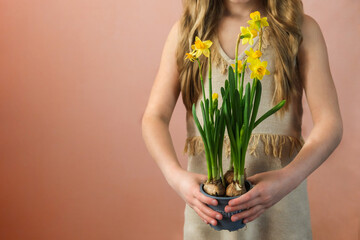 A bouquet of yellow daffodils in the hands of a happy girl. The florist girl collected a bouquet. Beautiful spring white flowers. Holiday gift. Spring mood.
