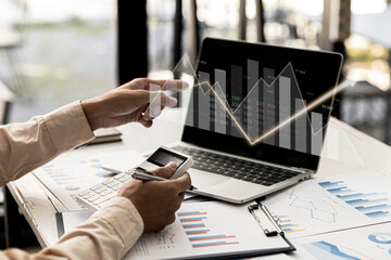A business man examines data on financial documents, company financial reports, graphics showing...