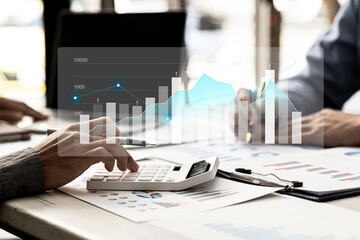 Two businessmen are meeting together, they point to financial documents to discuss plans and solutions, chart graphics showing financial status and performance. Business administration concept.