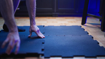 Person preparing rubber flooring material for exercise protection at home 4K