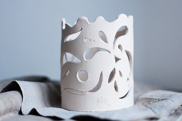 white clay openwork vase for dried flowers on a white background - obrazy, fototapety, plakaty