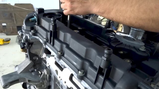 Car mechanic assembles engine after overhaul. Close up.