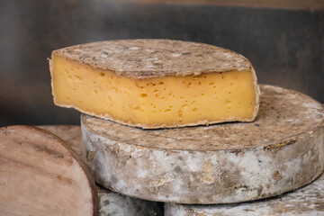 tomme cheese cut and whole close-up
