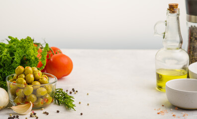 Selected tomatoes, herbs, garlic, green olives, olive oil, black pepper on a white background. Organic food, healthy lifestyle, vegetarian food. There is an empty space to insert. Food background.