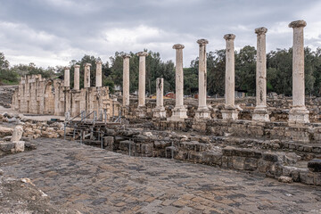 Fototapeta premium View of the Decumanus, east-west oriented street, perpendicular to the Cardo, with a row of columns in the Ancient Roman city in Beit Shean Nationl Park, Jordan Valey, Northern Israel, Israel