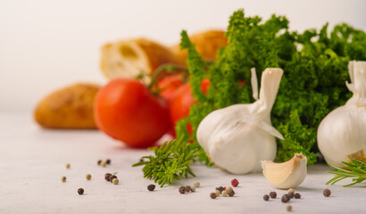 Obraz na płótnie Canvas Macro shot. Organic products - garlic, herbs, tomatoes, black pepper on a white background. Culinary background. Healthy vegetarian and diet food, vitamins, antioxidants.