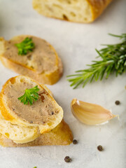 Canape with foie gras, parsley leaves, rosemary sprig on a white background. High angle view. Restaurant, banquet, buffet, gourmet food. Culinary background.