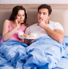 Happy family having breakfast in bed