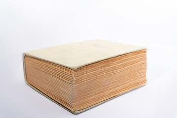 Old book with yellowed pages and a cloth cover. Thick book isolated on a white background.