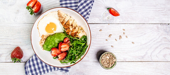 Delicious breakfast or snack Buddha bowl with Chicken salad with arugula and strawberries. Healthy food, ketogenic diet, diet lunch concept. Keto Paleo diet menu. Top view
