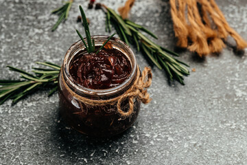Red onion marmalade jam confiture in jar. Vegetable jam on dark background. Delicious sauce. French cuisine. Food recipe background. space for text