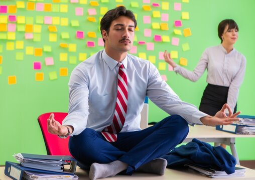 Man And Woman In The Office With Many Conflicting Priorities In