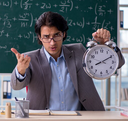The young handsome math teacher in classroom