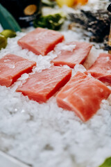 Chilled steaks of red fish. Pieces of fish lie on ice. Freezer shop window