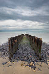 Pier with wooden posts at the North Sea coast in the province of Zeeland, The Netherlands