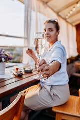 Woman eating fresh oysters and drinking chilled prosecco wine on the summer sunset. Seafood delicacies