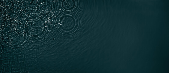 Black transparent clear calm water surface texture with ripples, splashes. Abstract nature banner background. Dark grey water waves in sunlight Copy space Cosmetic moisturizer micellar toner emulsion