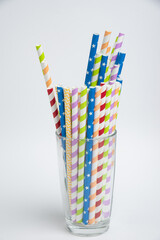 Colorful drinking paper straws for summer cocktails on white background. Copy space.