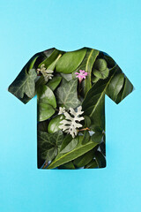 Paper cut t-shirt shape filled with green leaves. Organic cotton production, sustainable, ethical shopping, slow, circular fashion concept