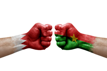 Two hands punch to each others on white background. Country flags painted fists, conflict crisis concept between bahrain and burkina faso