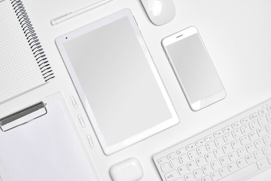 Top view of tablet and smartphone on white table