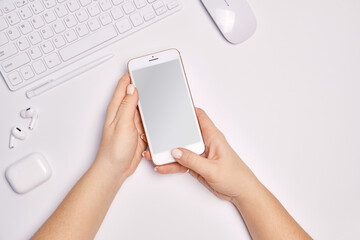 Freelance Feminine workspace with smartphone in female hands