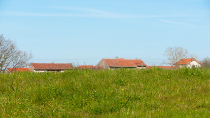 Tejados de casas rurales tras una colina de hierba © Darío Peña